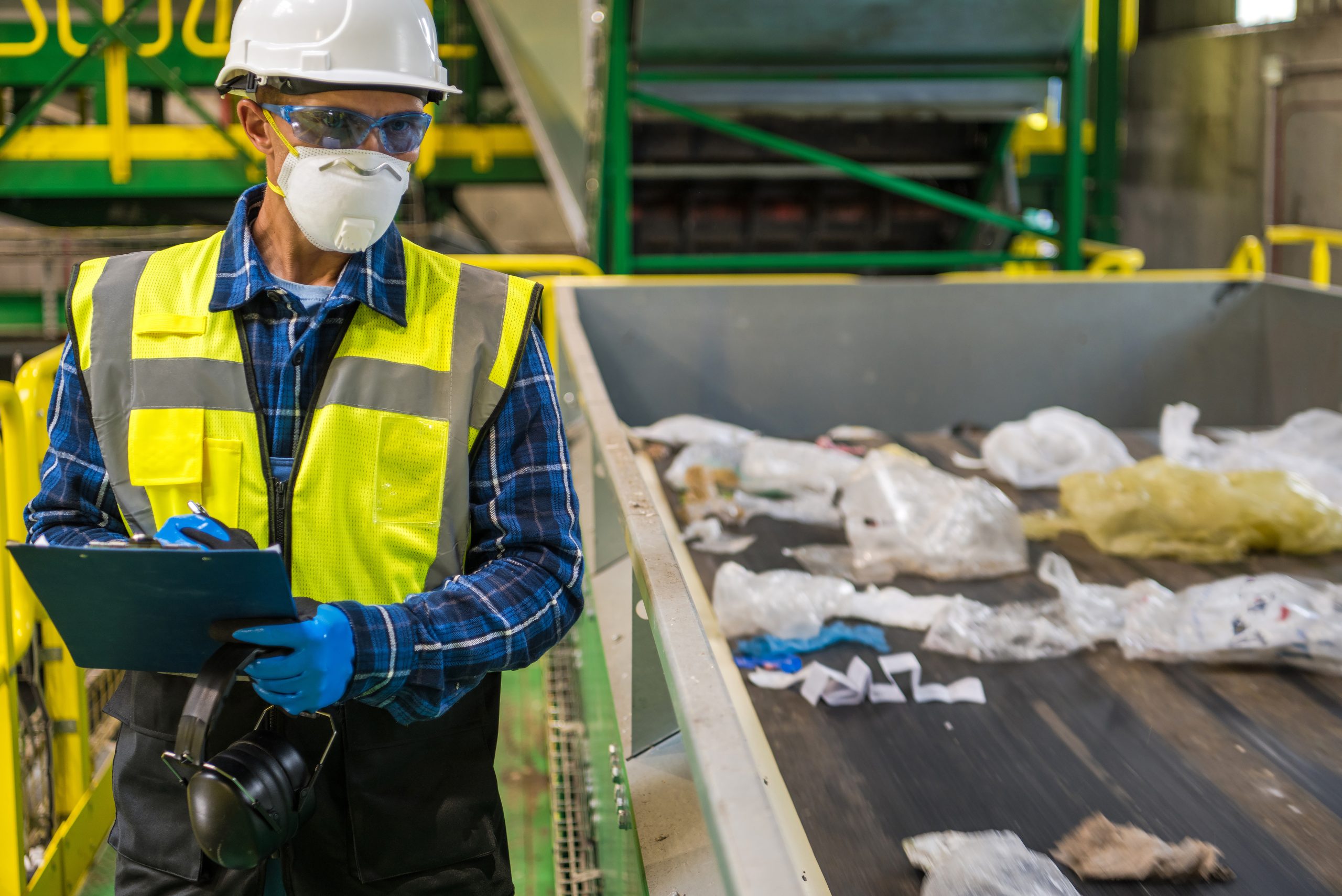 Un uomo controlla il processo di economia circolare dei rifiuti segnando le cose che non vanno bene e potrebbero mettere a rischio la salute e la sicurezza sul lavoro