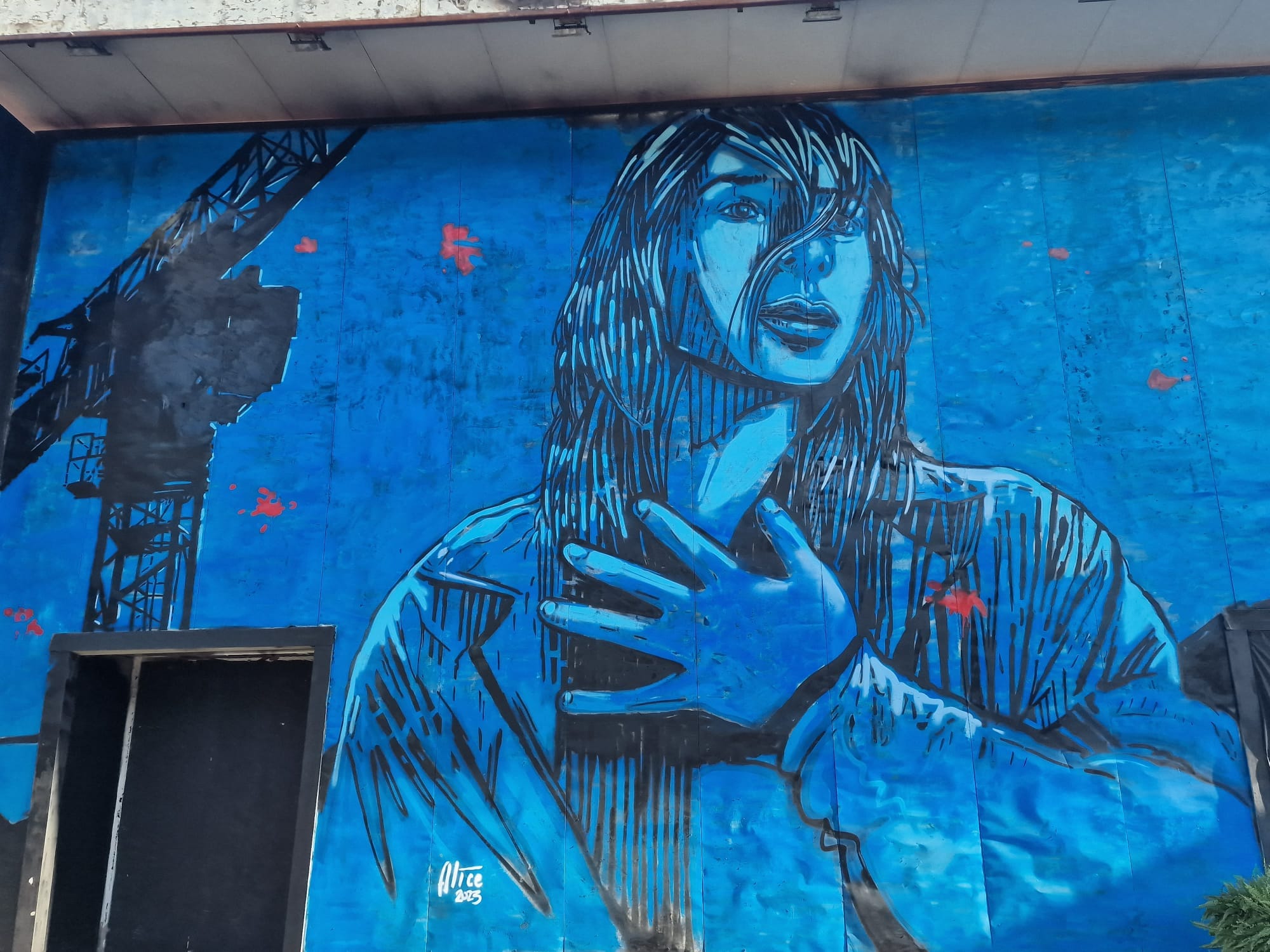 Murales a Roma che rappresenta una donna colpita dalla morte sul lavoro di un familiare